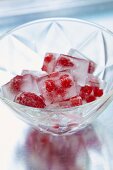 Berry ice cubes in a glass serving dish