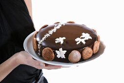A woman serving a chocolate cake