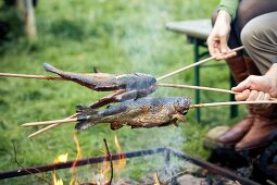 Steckerlfische werden über Feuer gegrillt