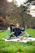 A couple having a picnic in a field in autumn
