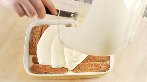 Preparing tiramisu: covering the second layer with mascarpone cream