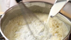 Milk being added to a roux