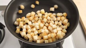 Croutons being roasted in a pan