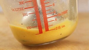 Egg yolk being mixed with water and mustard