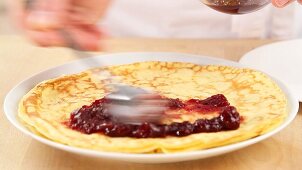 Crepes being spread with jam