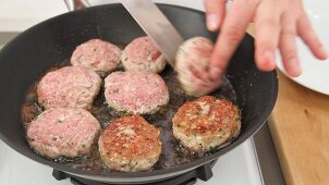 Burgers being turned in a pan