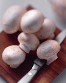 White Button Mushrooms on a Cutting Board; Knife