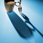 Kaffeetasse und Gabel mit Schatten