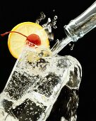 Pouring mineral water out of bottle into glass