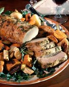 Roast pork, slices carved, with rosemary and vegetables
