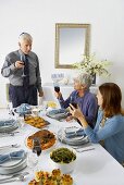 Man and Women Toasting with Red Wine Over Hanukkah Dinner Table