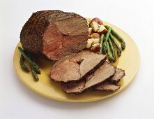 Partially Sliced Roast Beef with Asparagus and Red Potatoes