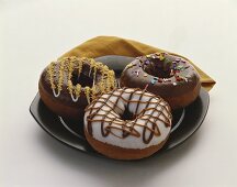 Drei Doughnuts mit Schokolade- und Vanilleglasur