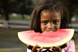Young Girl Eating a Large Wedge of Watermelon