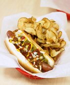 Hot Dog mit Ketchup, Senf, Zwiebeln, Relish und Chips
