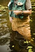 Man Standing in Water Fishing with Fly Fishing Pole