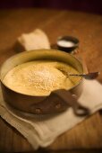 Creamy Polenta with Cheese in a Pot with Spoon