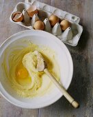 Mixing an Egg into Batter with a Wooden Spoon