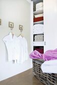 White blouses on hangers in the corner of a bathroom