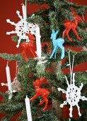A small Christmas tree decorated with crocheted snowflakes and plastic deer