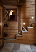 A wood panelled hallway with stairs in a hut