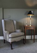 An armchair and a side table with a lamp