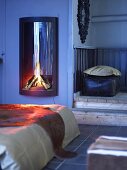 Wood burning stove with fire in a country style bedroom