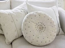 White embroidered pillows on a sofa