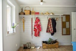 Ländlicher Hausflur mit weisser Holzverkleidung und Garderobe