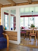 A rustic conservatory with a view of a table and wooden chairs