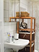 A wash basin and baskets on a wooden shelf in a bathroom
