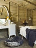 Rustikales Zimmer mit Holzwänden - Fell auf Bett und weisser Schminktisch
