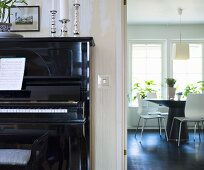Piano and a view into a dining room with designer furniture