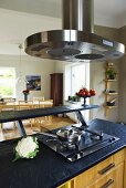 A slate work surface with a fitted gas cooker and a stainless steel extractor fan