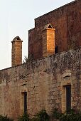 Steinfassade einer romanischen Burg im Abendlicht