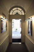 Hallway with an open front door with a fanlight with a view onto a street