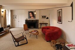 Adjustable wall lighting in a living room with a sofa upholstered in red and 50's seating on sisal flooring