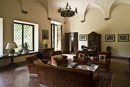 Elegant living room in an old villa with vaulted ceiling and a living room suite covered in red velvet