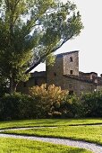 Garden with a gravel path and a view of a Mediterranean villa