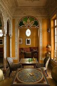 Eleganter marokkanischer Salon mit Wandbemalung und Blick durch Rundbogen auf Sofa