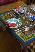 A place setting with wine glasses on an Oriental table