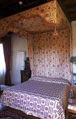 Bedroom in a country home -- canopy bed with floral pattern