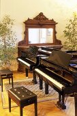 Two pianos with a piano bench in a music room