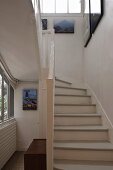 Looking up a country style stairway with white treads and railing