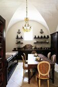 A vaulted ceiling in a dining room with dark wooden furniture and a chandelier