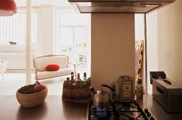 Open kitchen -- kitchen unit with integrated stove and view of an antique upholstered sofa in the living room