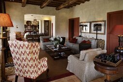 The cozy living room of a country house with a wingback chair and gray sofa suite