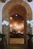 View through a brick arch of bathroom furnishings with atmospheric lighting