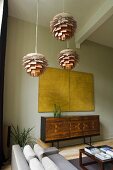 Bauhaus-style ceiling lamps and a yellow picture hanging above a designer sideboard