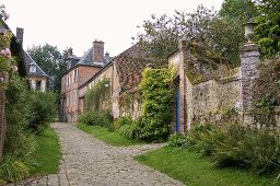 Bürgerhaus mit Ziegelfassade und Steinmauer an alter Dorfstrasse